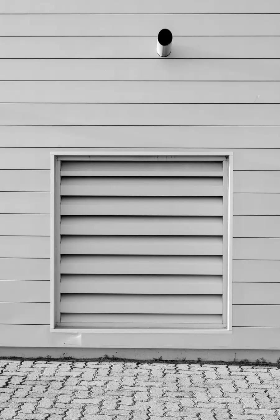 Large louvered vent set into lap siding